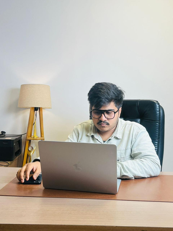 Kshitij at his desk, editing on a laptop